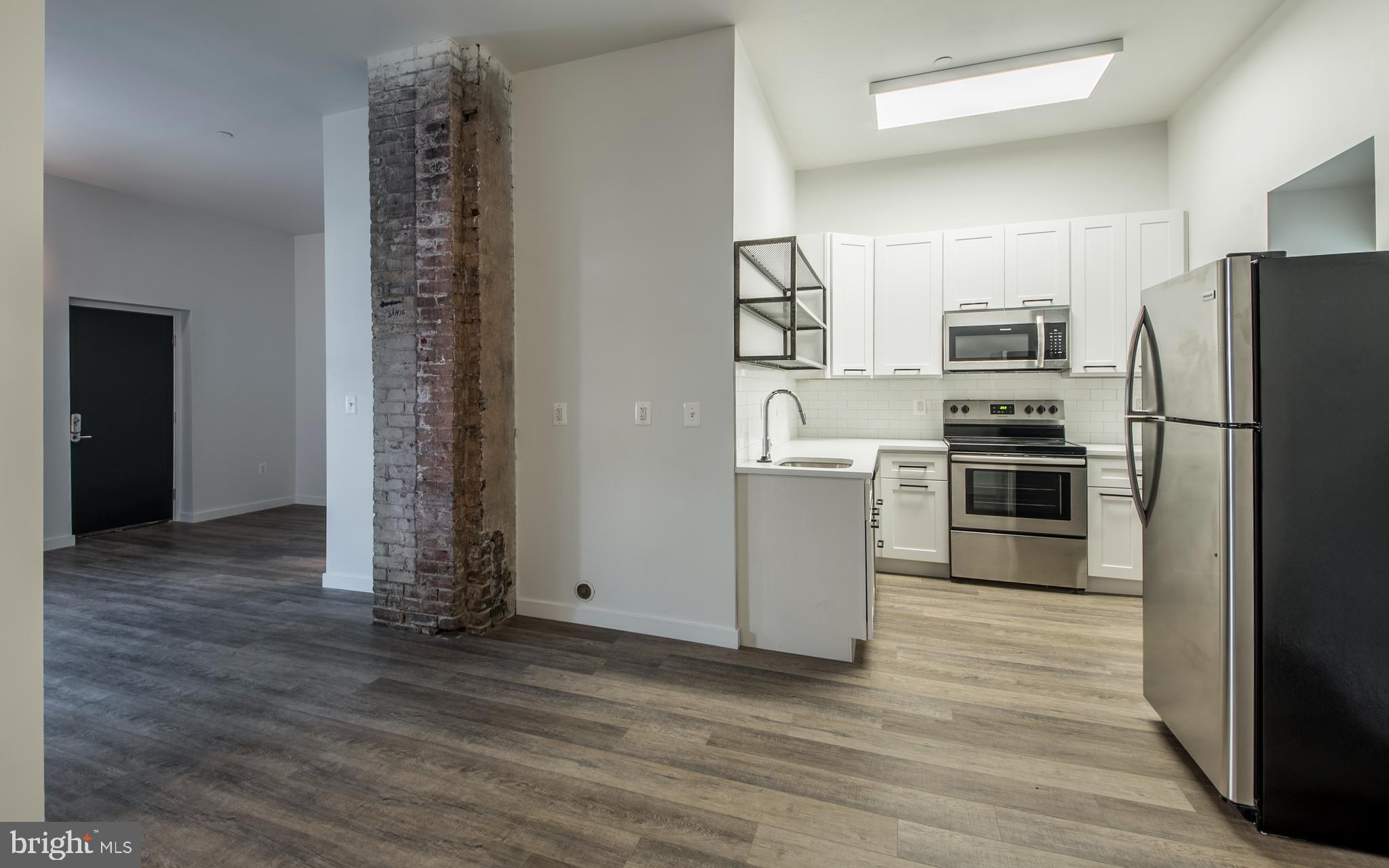 1201 Jackson Street, Unit 428 Philadelphia, PA 19148 - Photo 34 of 46 a kitchen with stainless steel appliances a refrigerator and a stove top oven