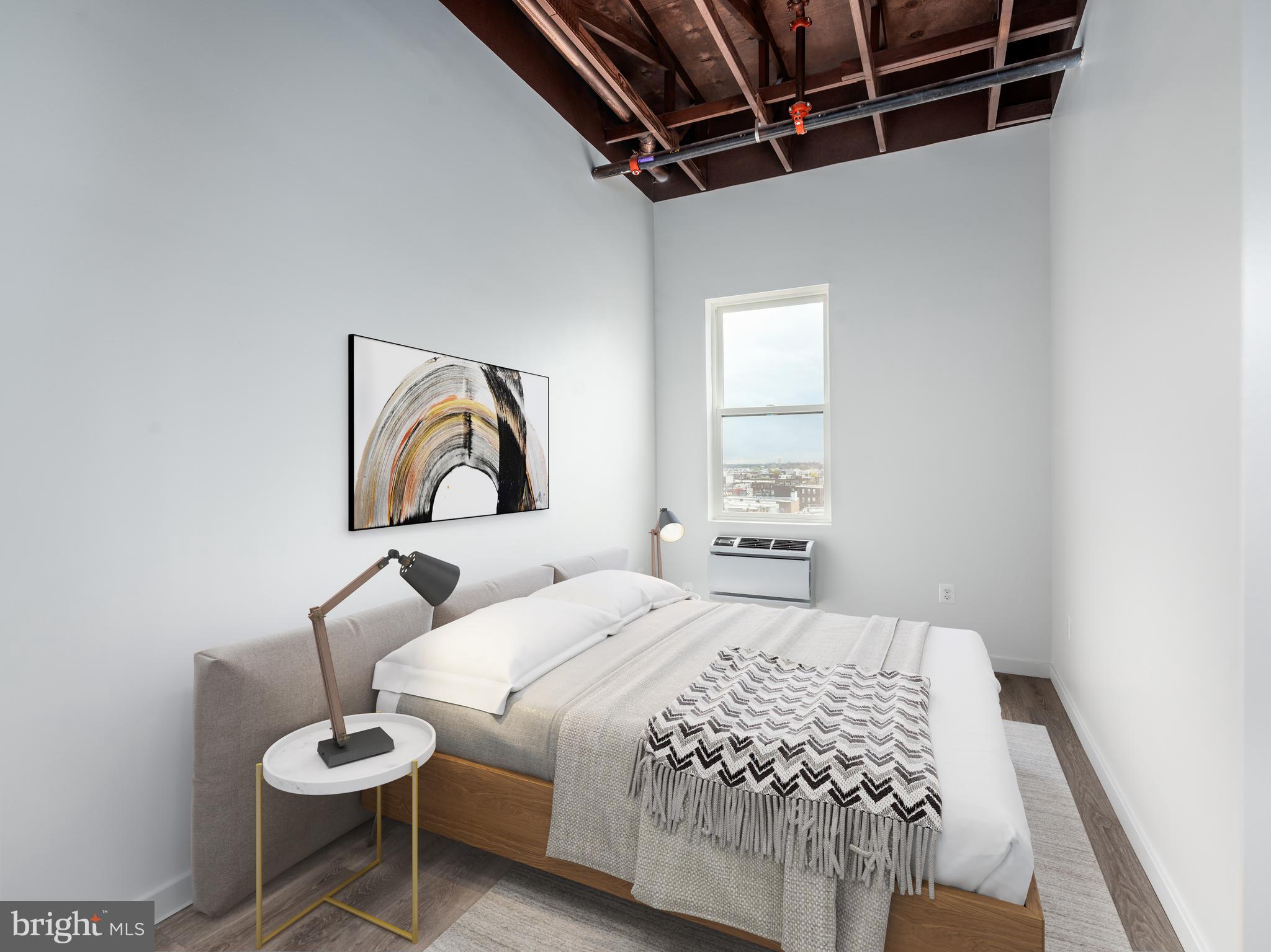 1201 Jackson Street, Unit 428 Philadelphia, PA 19148 - Photo 46 of 46 a bedroom with a bed and wooden floor