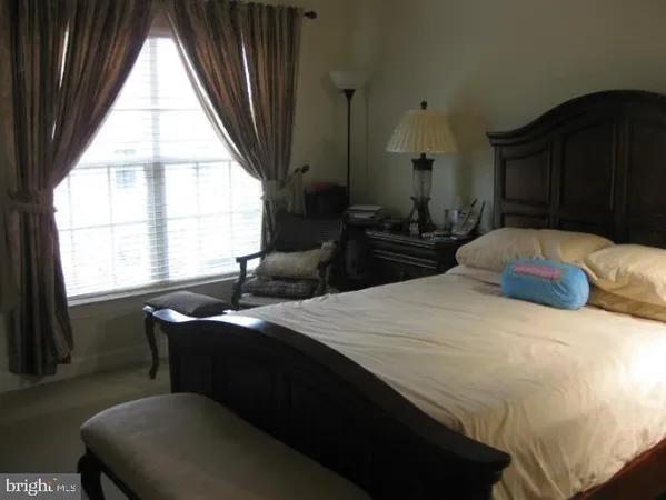 a bedroom with a bed and a large window