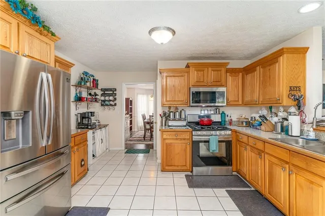 a kitchen with stainless steel appliances granite countertop a refrigerator and a stove top oven