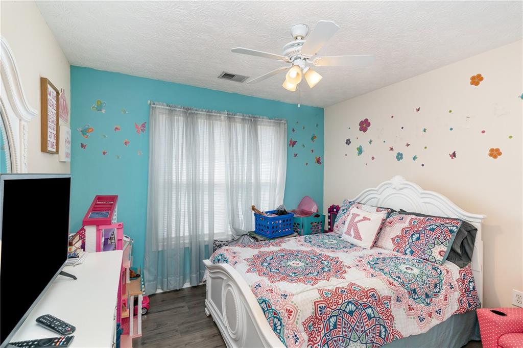 40 Cindy Circle Covington, GA 30016 - Photo 30 of 34 a bedroom with a bed and a chandelier