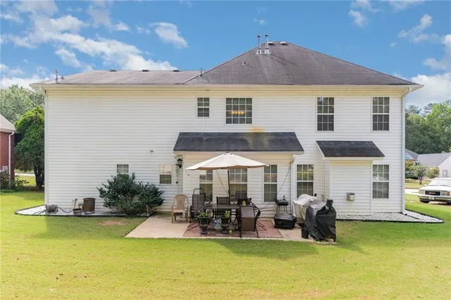 a view of swimming pool with outdoor seating and house in the background
