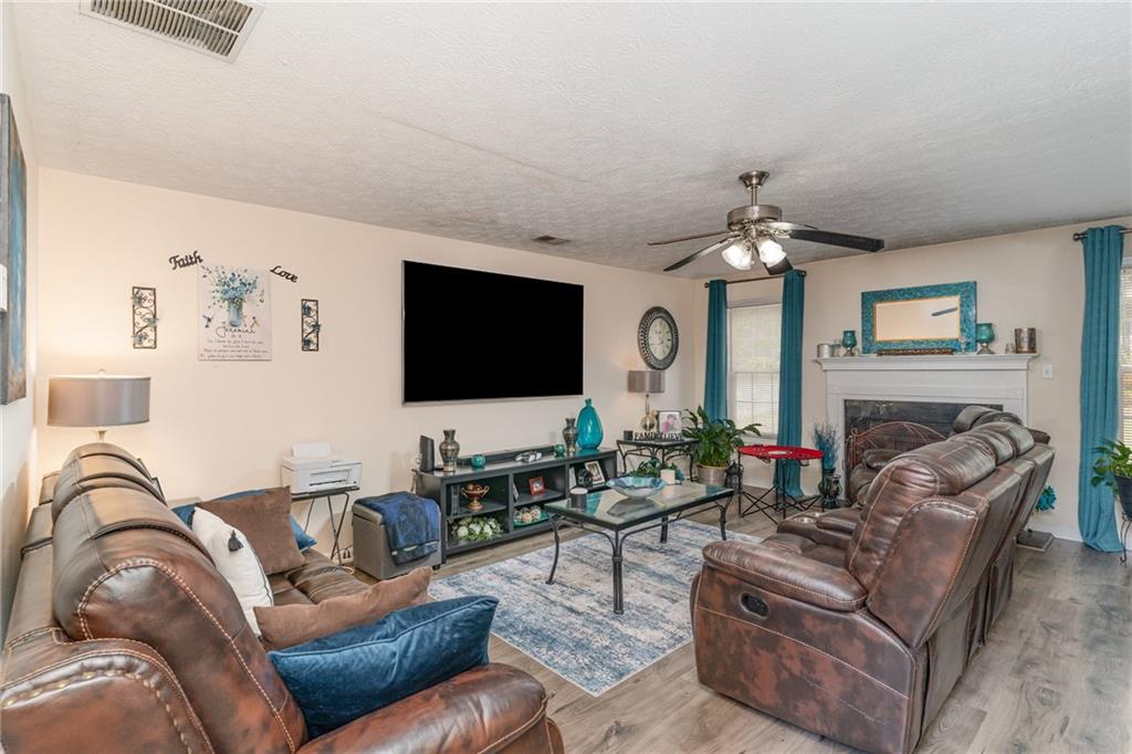 40 Cindy Circle Covington, GA 30016 - Photo 9 of 34 a living room with furniture a flat screen tv and a fireplace