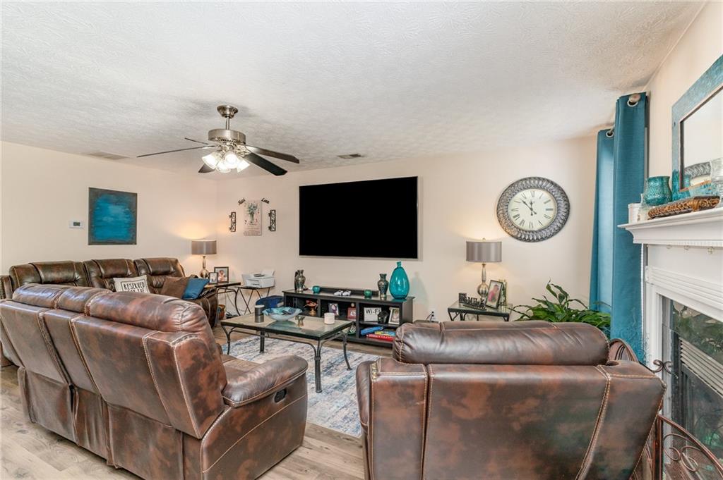 40 Cindy Circle Covington, GA 30016 - Photo 10 of 34 a living room with furniture a clock and a flat screen tv
