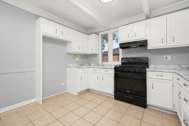 a kitchen with white cabinets and appliances