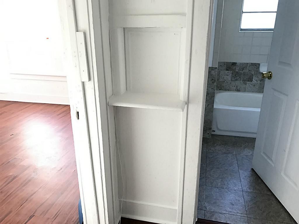 531 Threlkeld Street Houston, TX 77007 - Photo 12 of 15 a view of a hallway with wooden floor and a bathroom