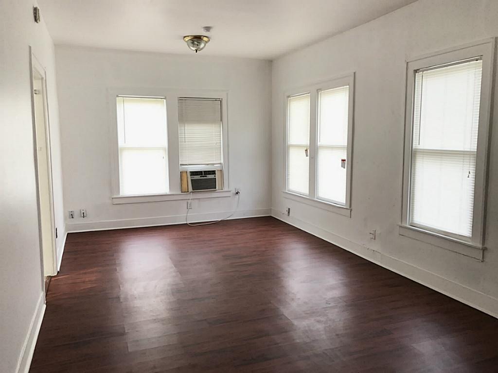 531 Threlkeld Street Houston, TX 77007 - Photo 5 of 15 an empty room with wooden floors and windows