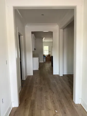 a view of a hallway with wooden floor