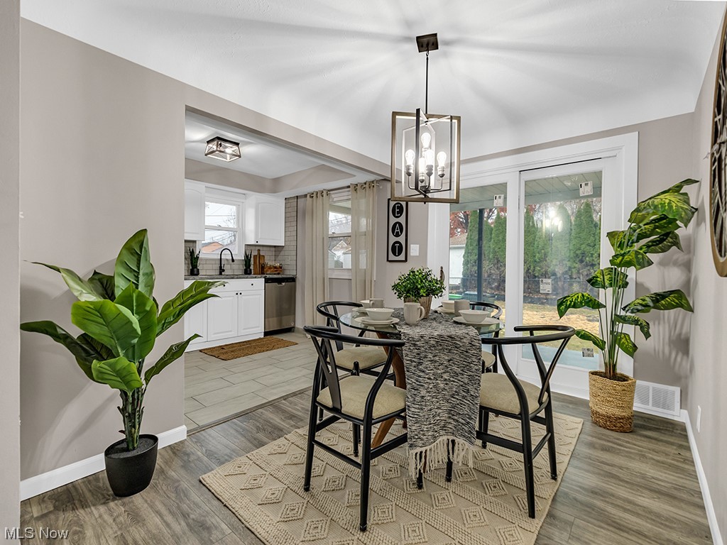 1661 Rush Road Wickliffe, OH 44092 - Photo 5 of 26 Dining area featuring a notable chandelier, sink, and light hardwood / wood-style flooring