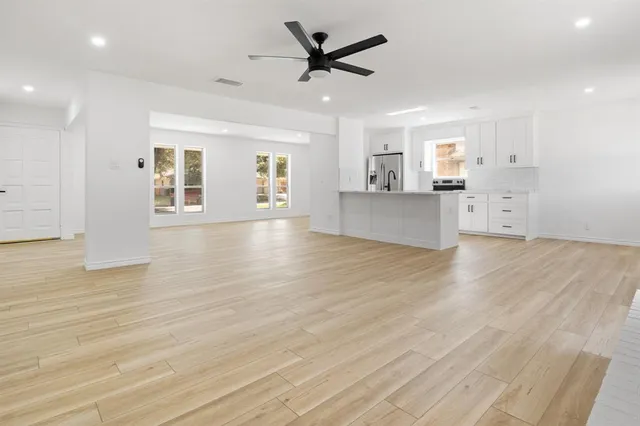a view of a big room with wooden floor and a ceiling fan