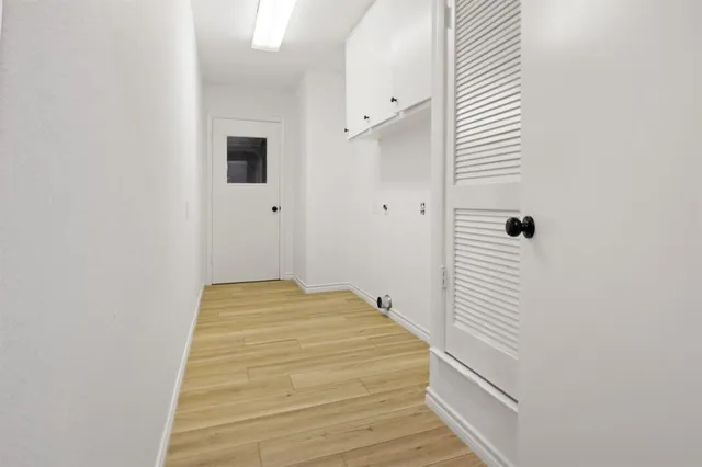 a large white kitchen with wooden floors and white walls