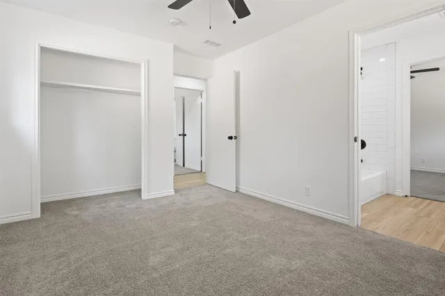 an empty room with a window and a ceiling fan