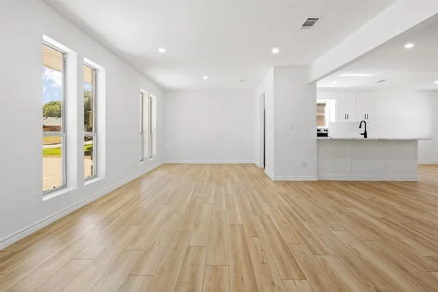 a view of a big room with wooden floor and windows