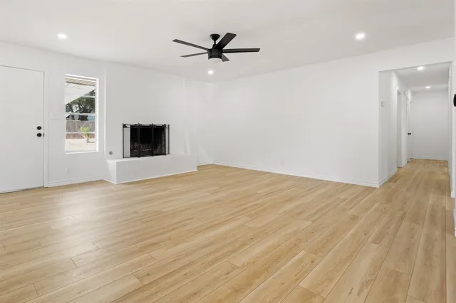 a view of a room with wooden floor and a ceiling fan