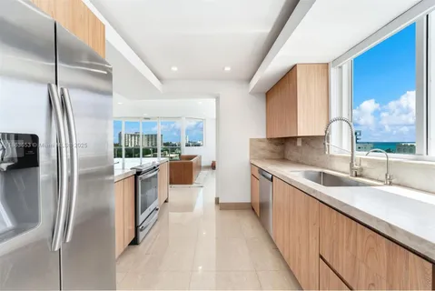 a kitchen with stainless steel appliances granite countertop a sink a stove and a refrigerator