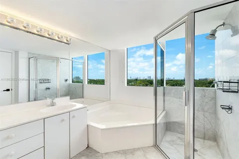 a spacious bathroom with a tub shower and windows