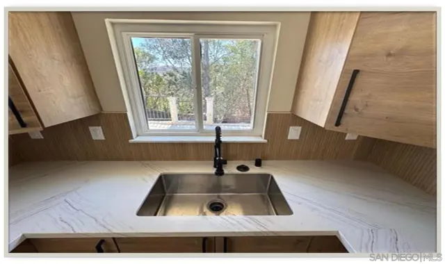a kitchen with kitchen island a sink wooden floor and a large window
