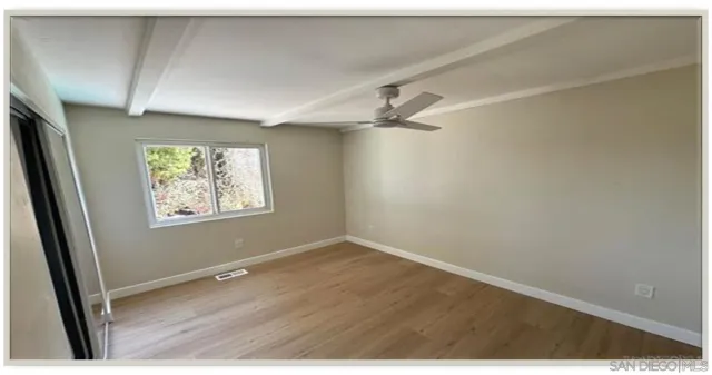 an empty room with windows and fan