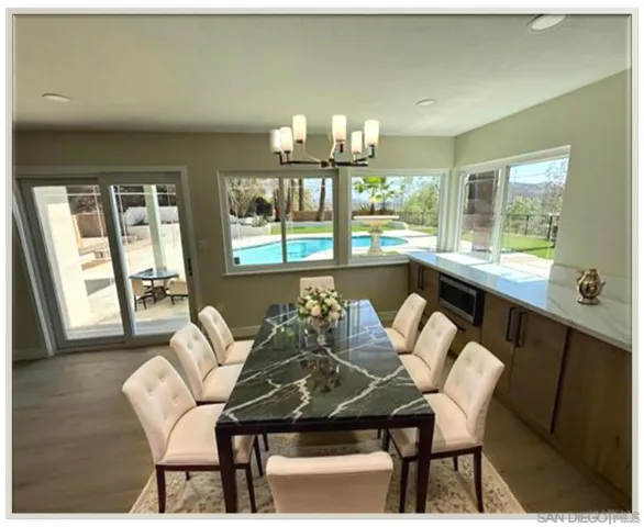 a dining room with furniture a chandelier and wooden floor