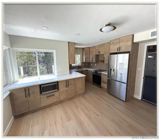a kitchen with stainless steel appliances wooden floors and wooden cabinets