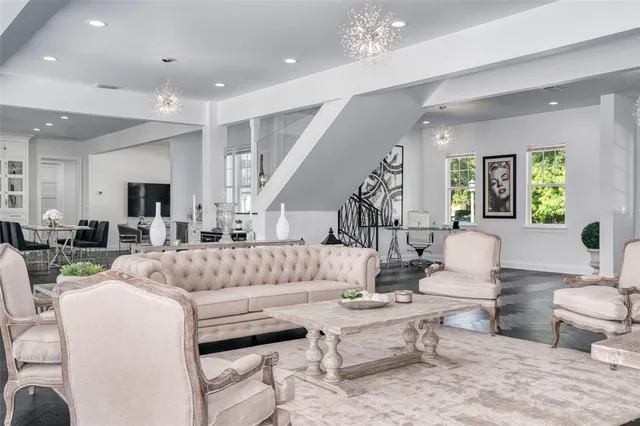 a living room with furniture a rug and a chandelier