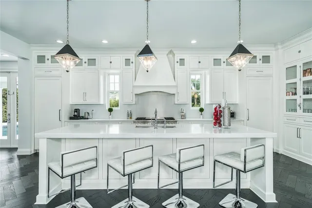 a kitchen with stainless steel appliances granite countertop a sink a stove and cabinets