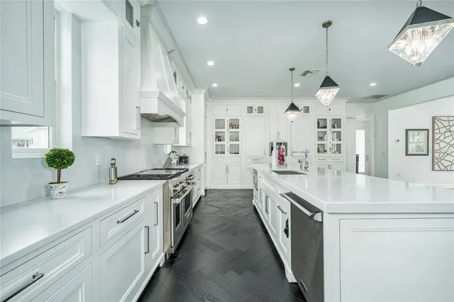 a kitchen with cabinets appliances and wooden floor