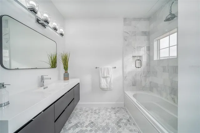 a bathroom with a granite countertop sink a mirror and a shower