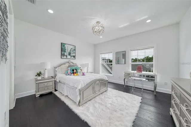 a en suite bathroom with double vanity mirrors and wooden floor