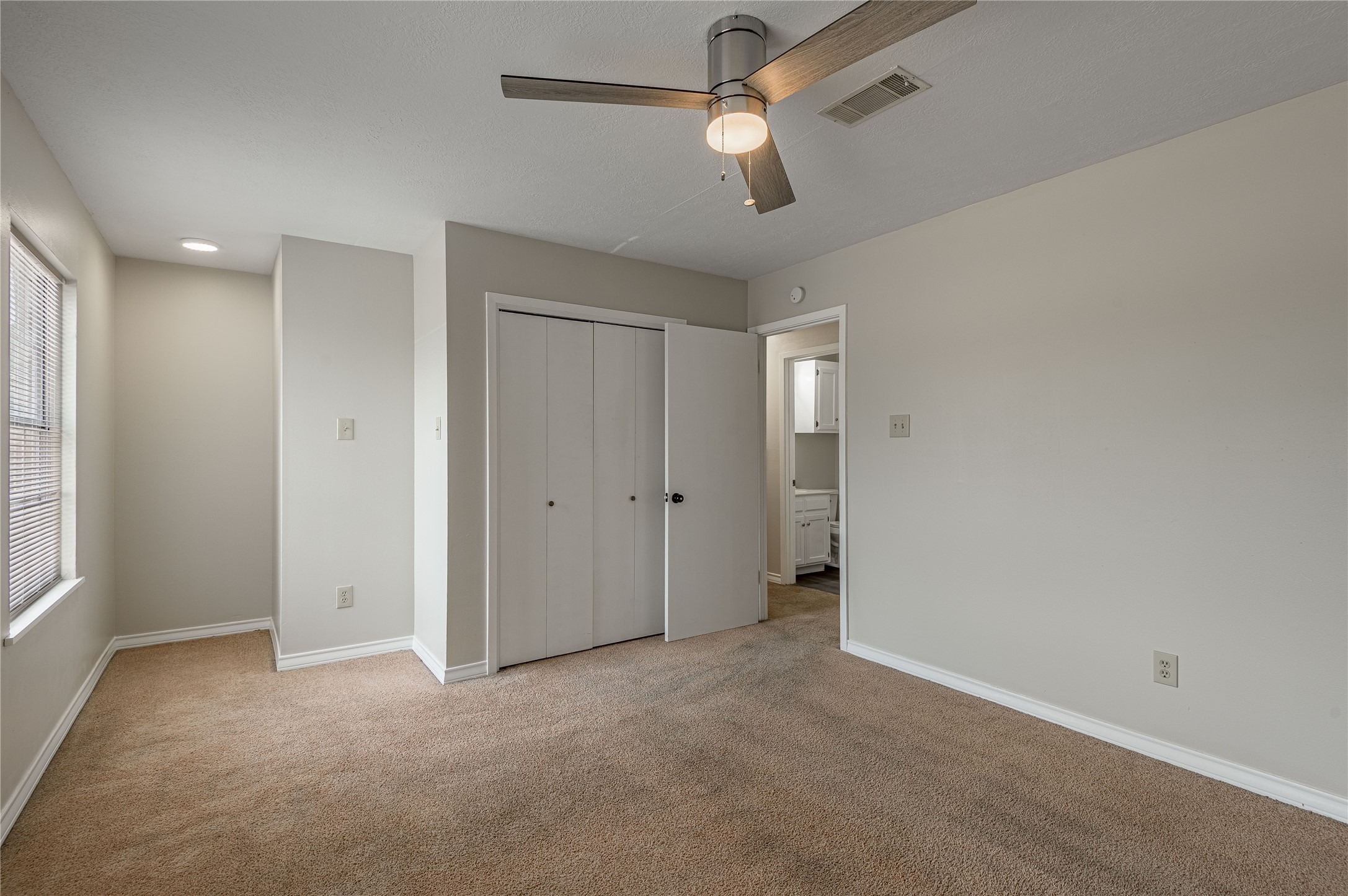 1401 Ave O, Unit F Huntsville, TX 77340 - Photo 16 of 26 an empty room with chandelier fan and windows