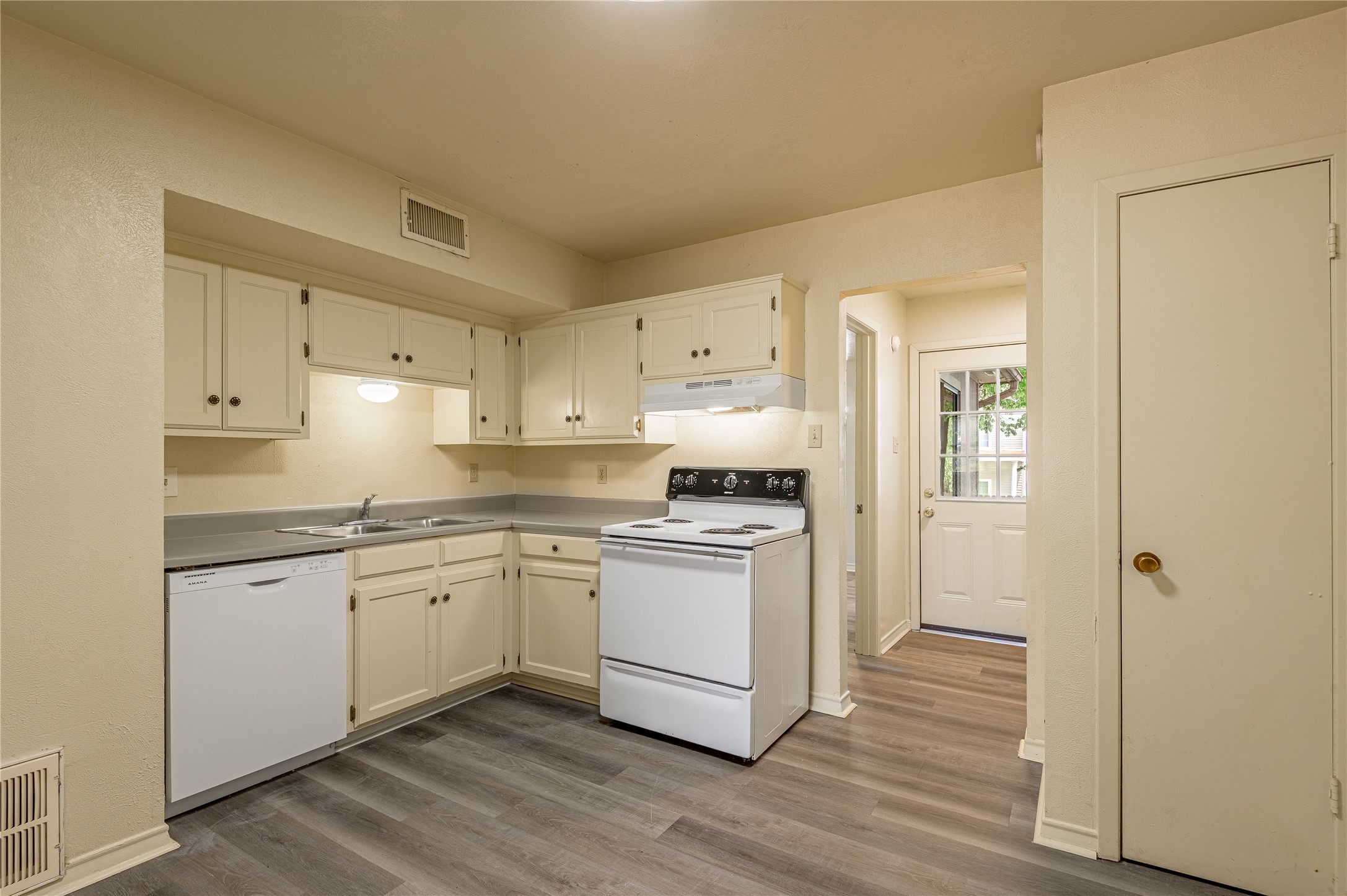 1401 Ave O, Unit F Huntsville, TX 77340 - Photo 5 of 26 a kitchen with stainless steel appliances granite countertop a stove a sink and white cabinets