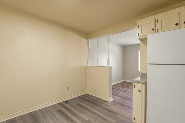 a view of hallway with wooden floor and cabinets