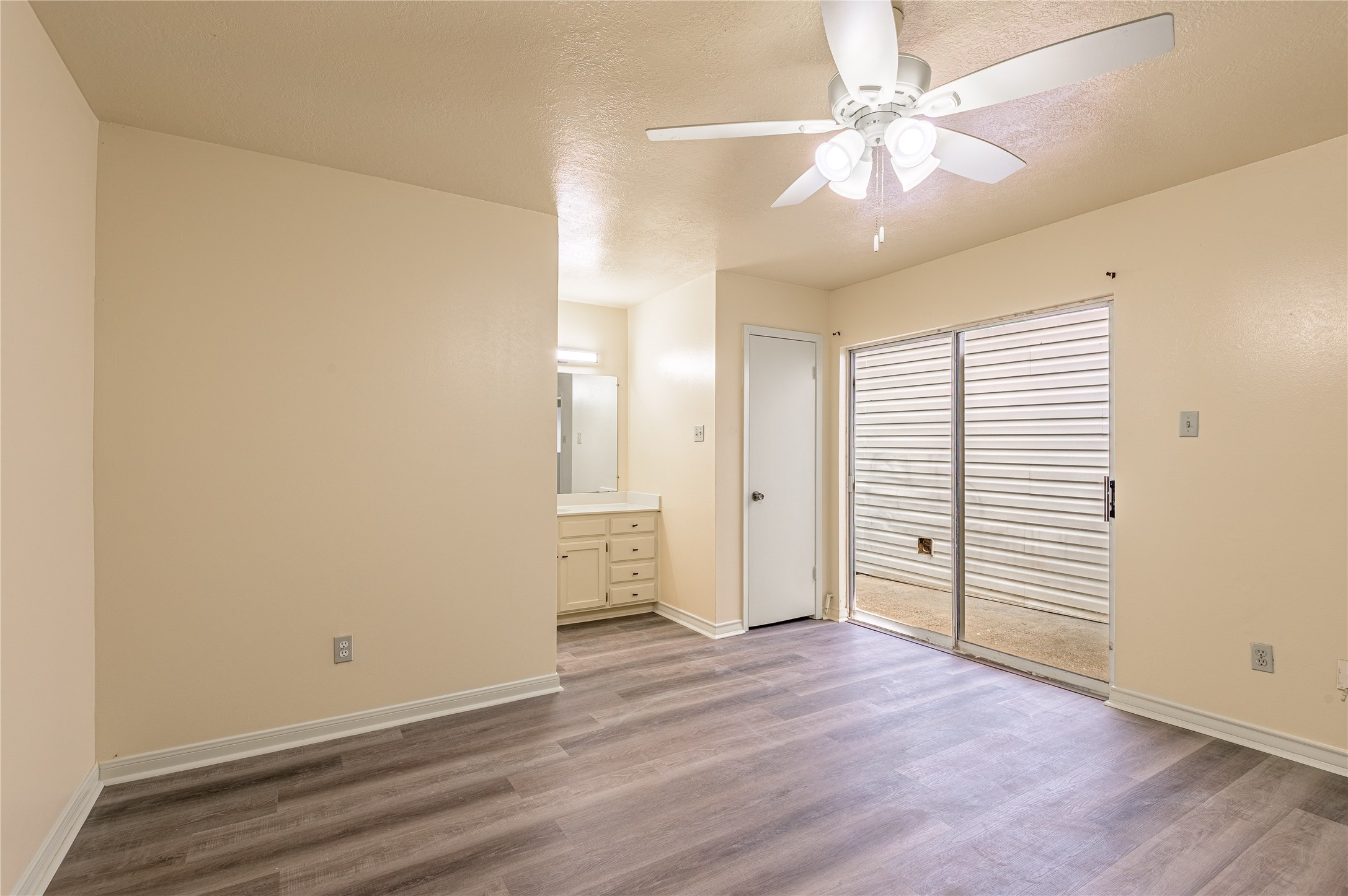 1401 Ave O, Unit F Huntsville, TX 77340 - Photo 10 of 26 an empty room with wooden floor and ceiling fan