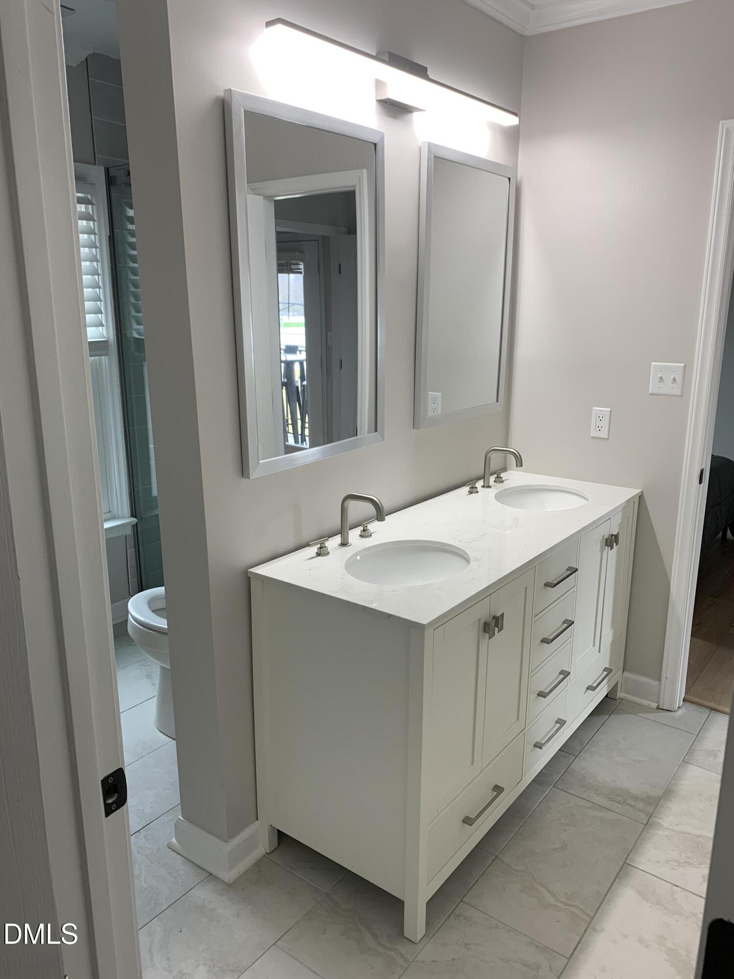 610 Hillsborough Street, Unit 205 Raleigh, NC 27603 - Photo 12 of 15 a spacious bathroom with a double vanity sink and a mirror