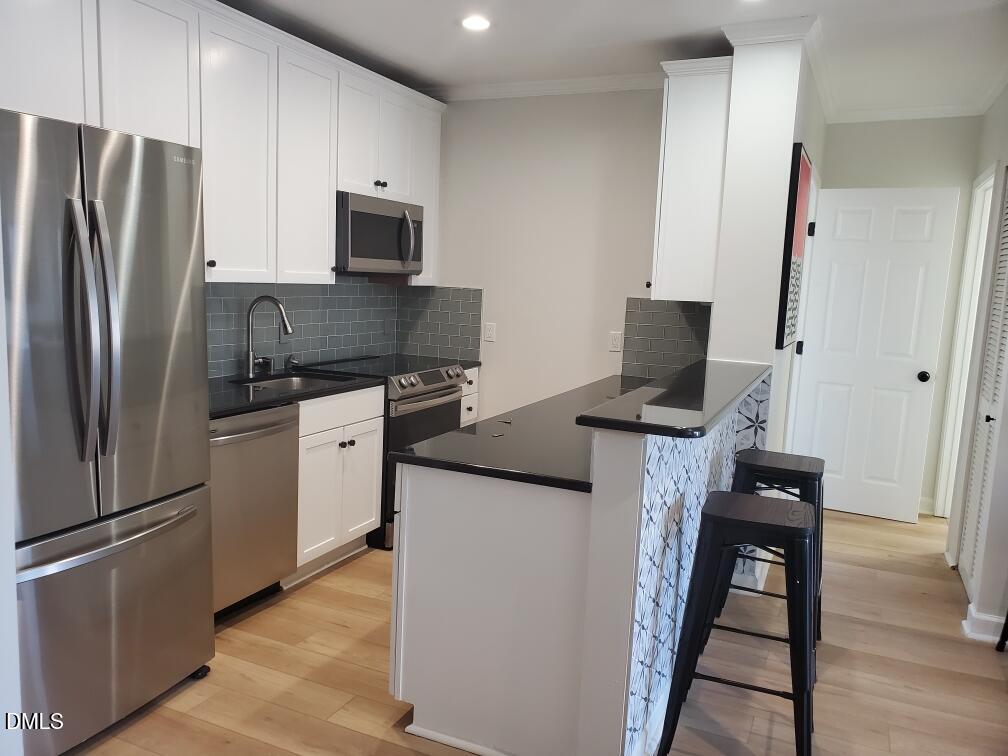 610 Hillsborough Street, Unit 205 Raleigh, NC 27603 - Photo 4 of 15 a kitchen with stainless steel appliances a refrigerator stove and microwave