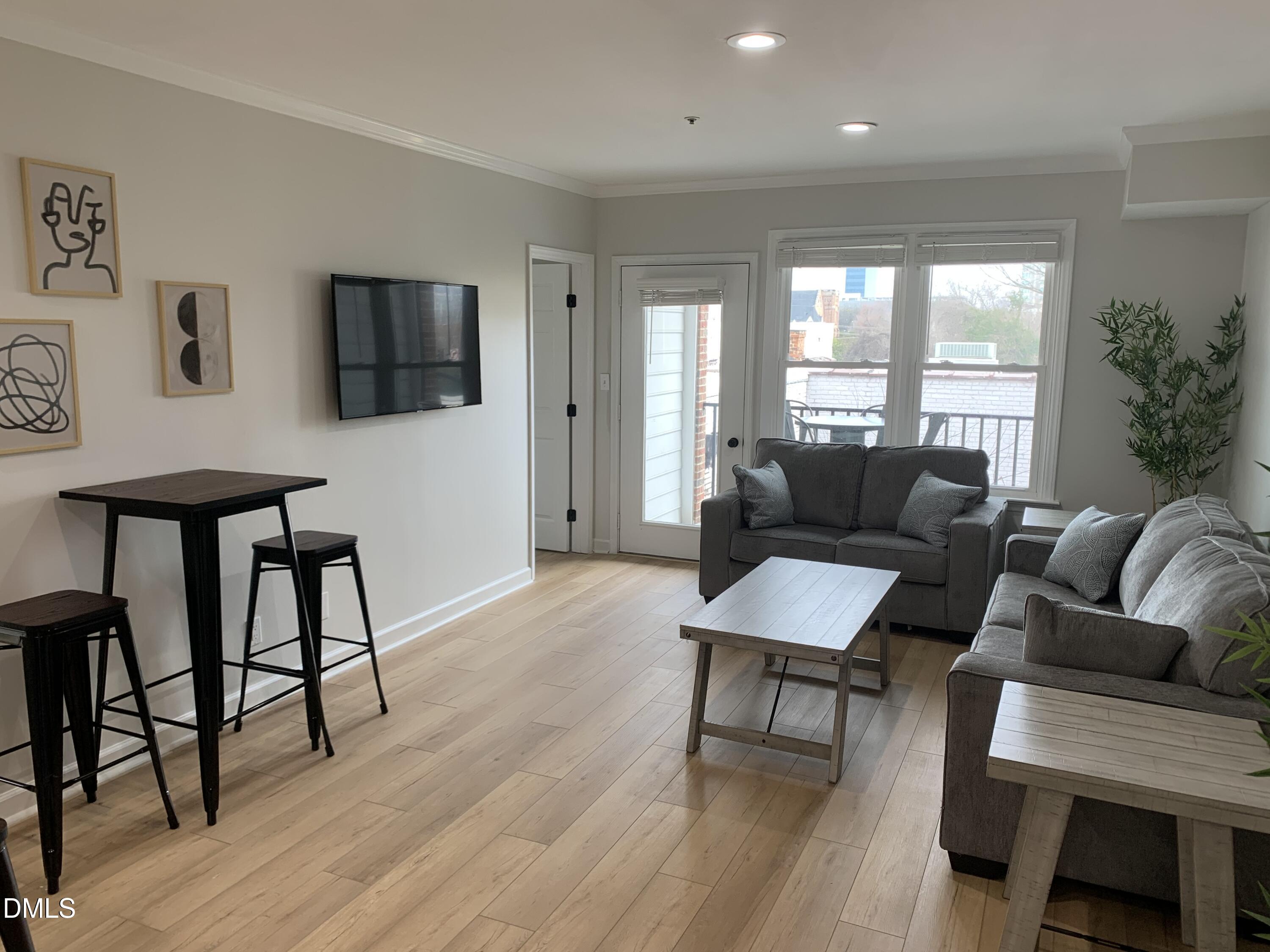 610 Hillsborough Street, Unit 205 Raleigh, NC 27603 - Photo 5 of 15 a living room with furniture and a wooden floor