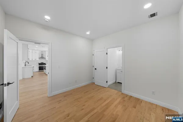 a view of a room with wooden floor and a bathroom