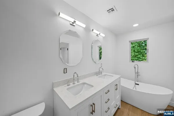 a bathroom with a double vanity sink and a mirror