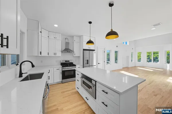 a kitchen with kitchen island granite countertop a stove a sink a counter space and a center island