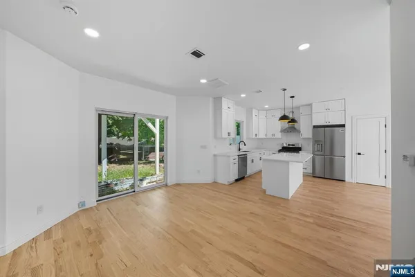 a large white kitchen with wooden floors and white doors
