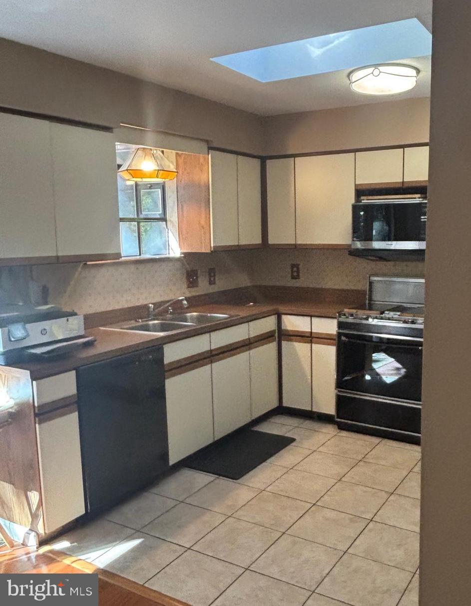 3160 Rolling Road Edgewater, MD 21037 - Photo 11 of 62 a kitchen with a stove a sink and a refrigerator