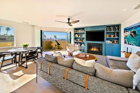 a living room with furniture a flat screen tv and a fireplace