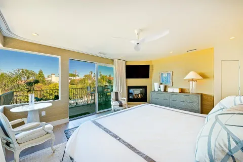 a spacious bedroom with a bed a fireplace and a flat screen tv