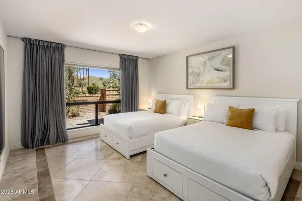 a bedroom with a bed and a large window