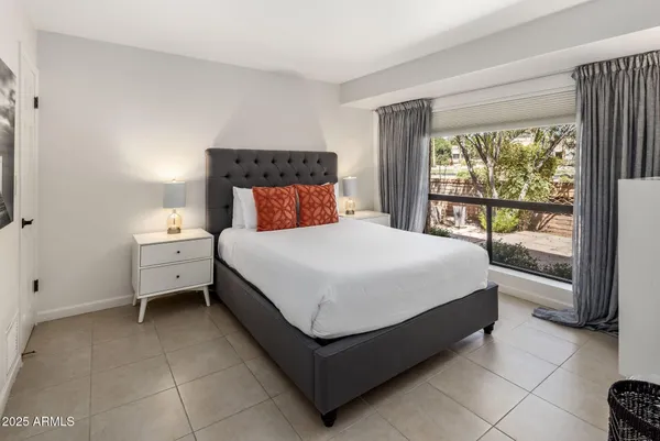 a spacious bedroom with a bed and a large window