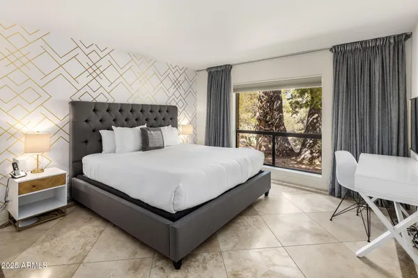 a bedroom with a bed chair and window