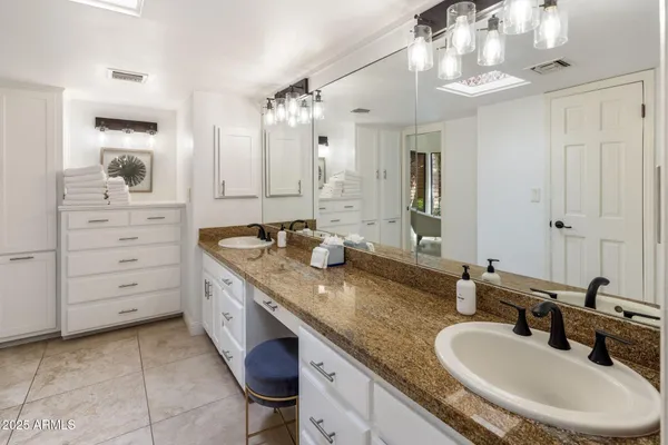 a bathroom with a granite countertop sink a large mirror and vanity