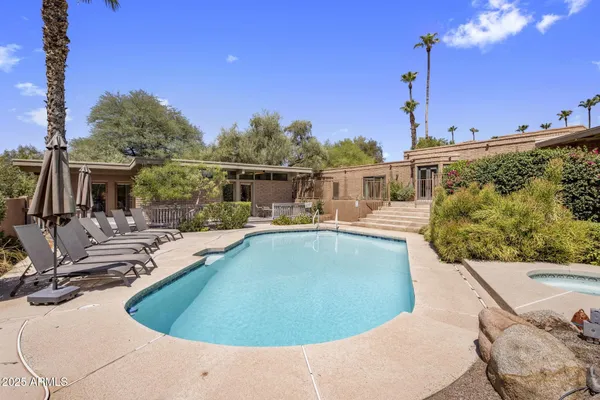a view of a swimming pool with a chairs and tables on the roof