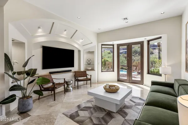 a living room with furniture floor to ceiling window and a flat screen tv