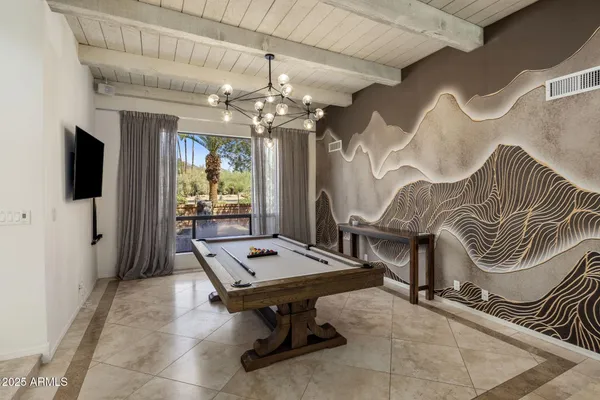 a living room with furniture a flat screen tv and a chandelier
